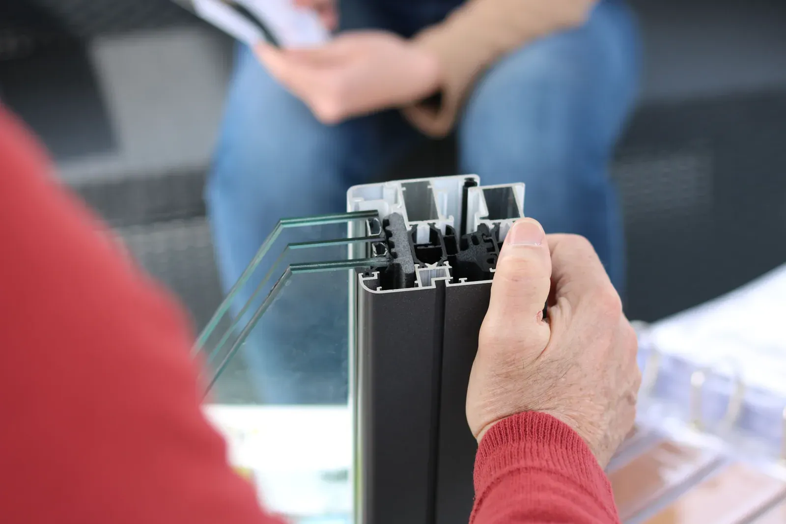 Person holding an aluminium window-frame sample