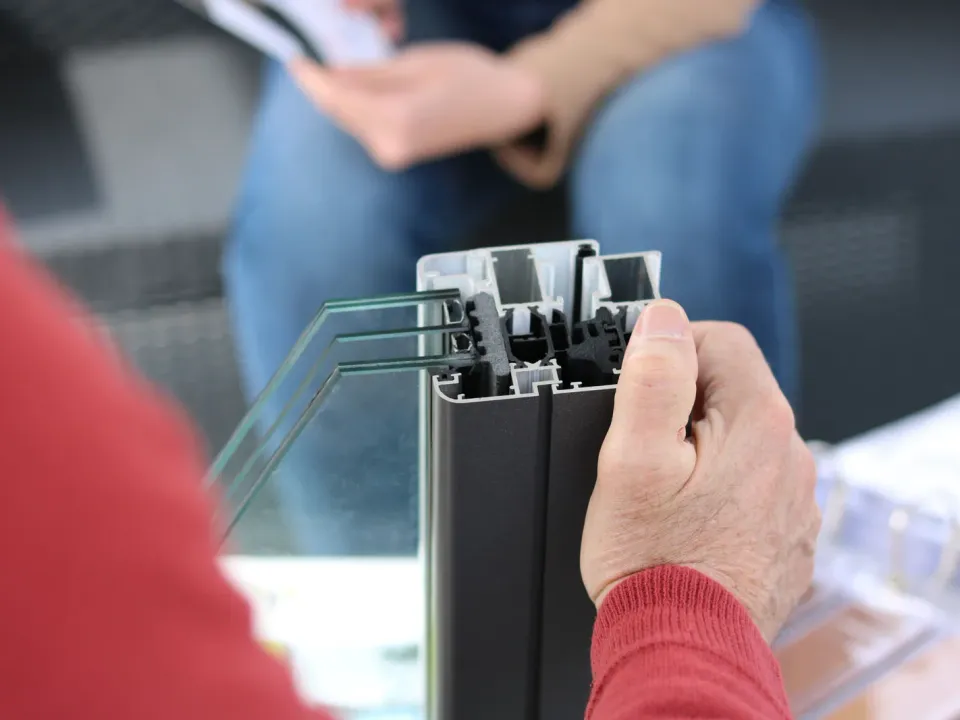 Person holding an aluminium window-frame sample — illustrative image; actual product may vary